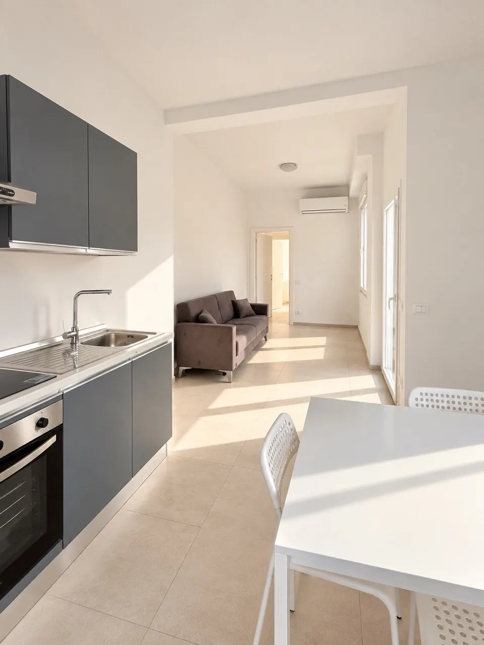 Cucina – Cucina con lavello, piano a induzione, forno e divano.