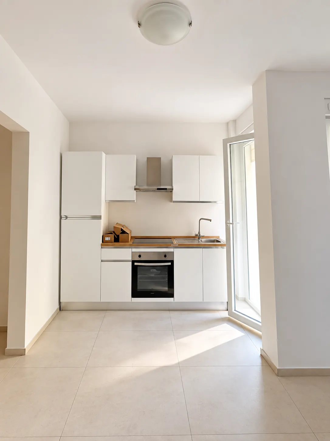 Zona cucina – Cucina con piano di lavoro, pensili e frigorifero.