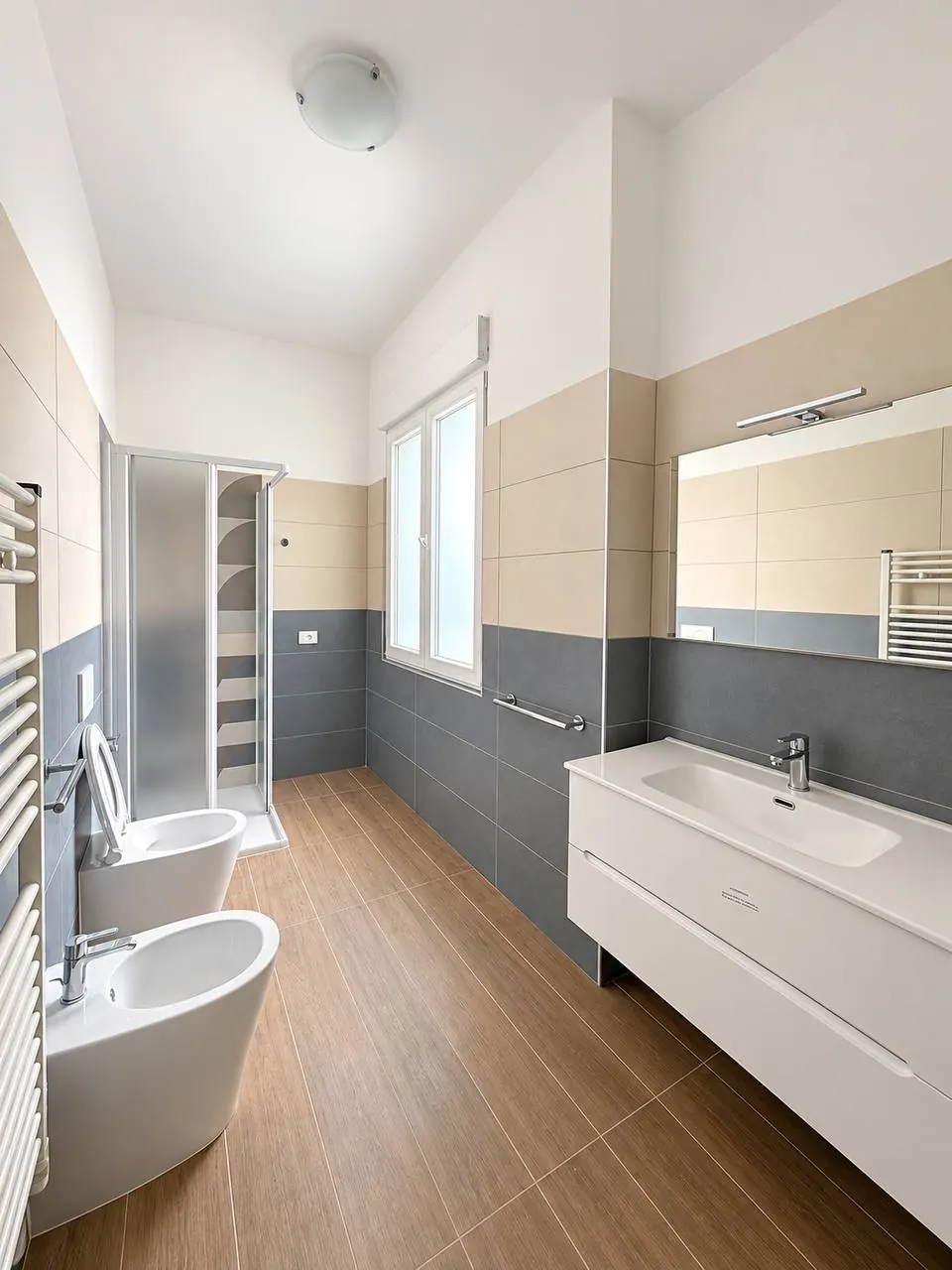 Bagno – Bagno con doccia, bidet, lavabo e finestra.
