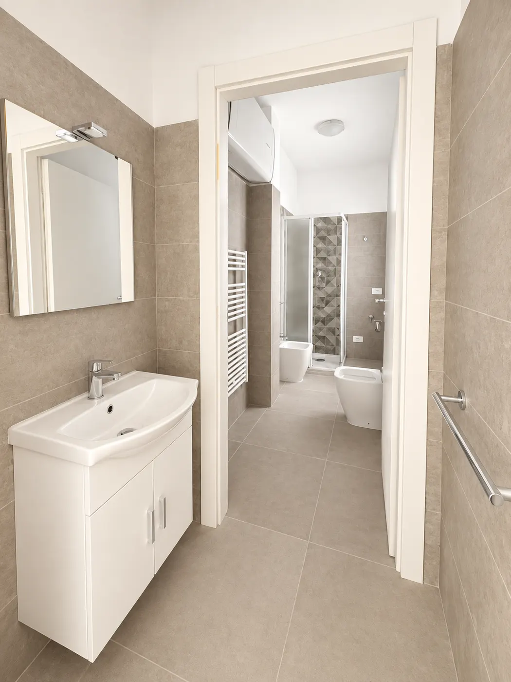 Bagno – Zona lavabo con specchio e accesso ai sanitari.