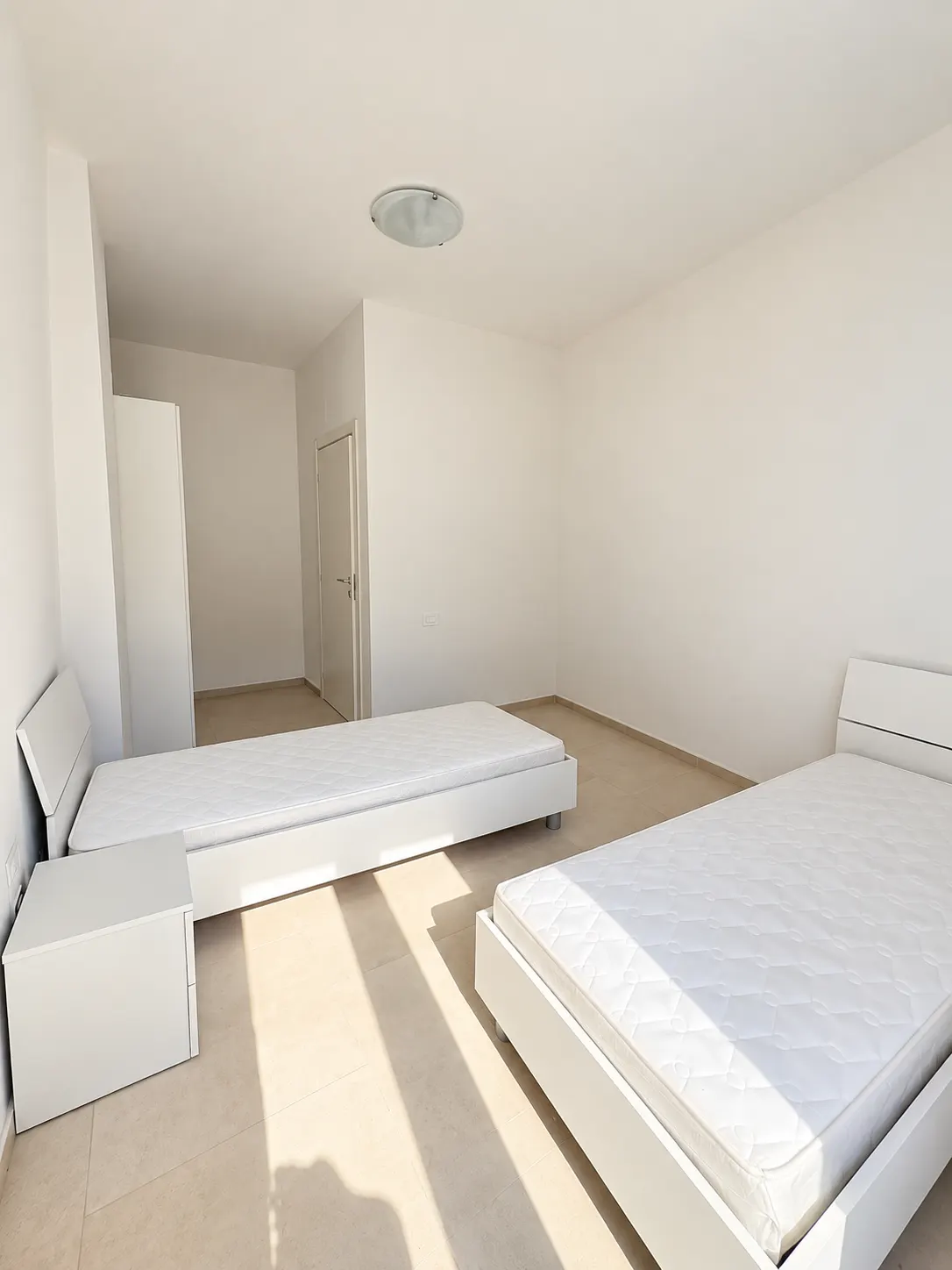 Camera doppia – Camera con due letti, comodino e porta.