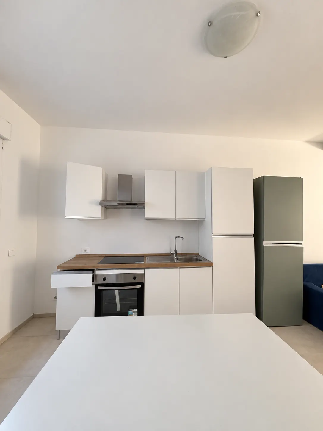 Zona giorno e cucina – Spazio con cucina, tavolo e frigorifero.