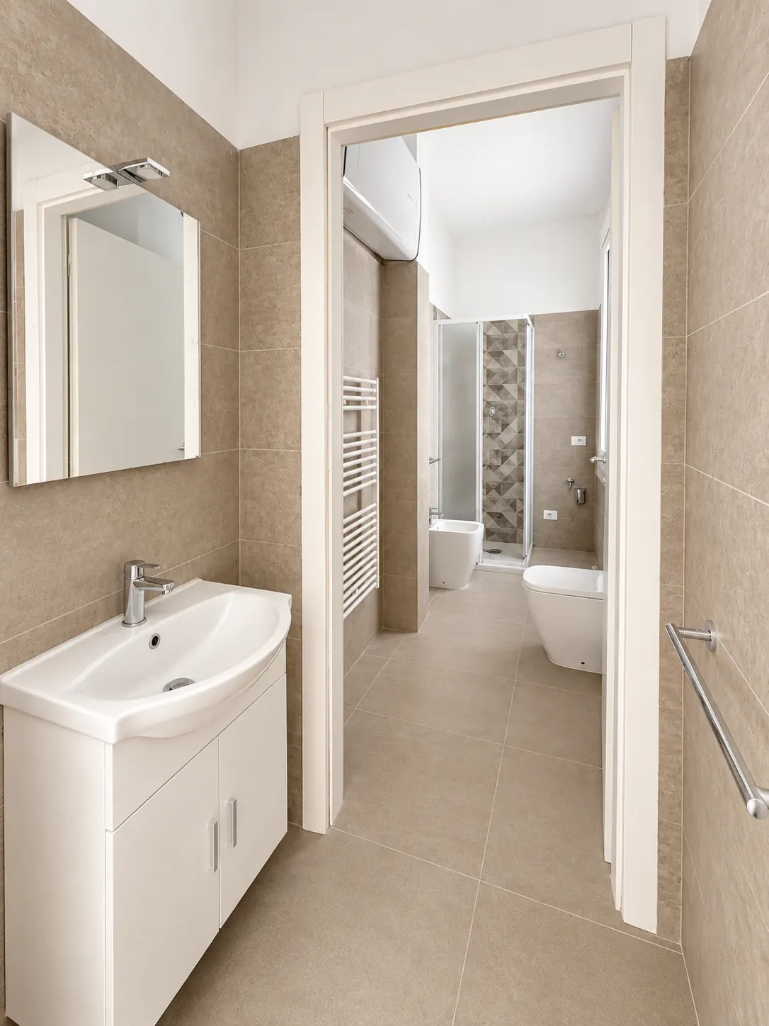 Bagno – Zona lavabo con specchio e accesso ai sanitari.